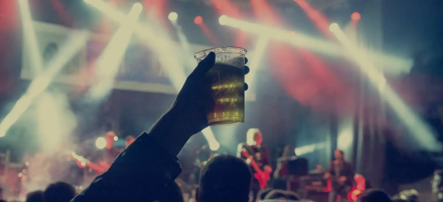 Raised beer glass in a crowd at a concert setting