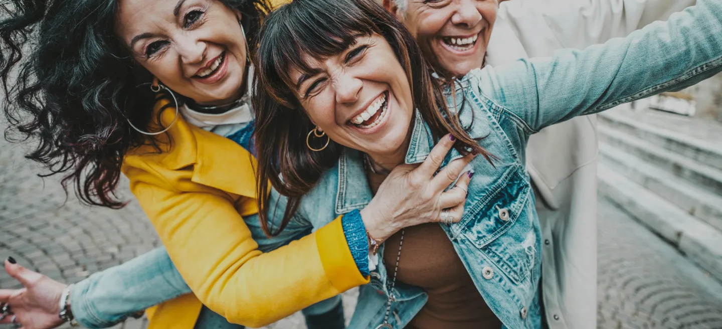 Three happy women having fun together on a city street