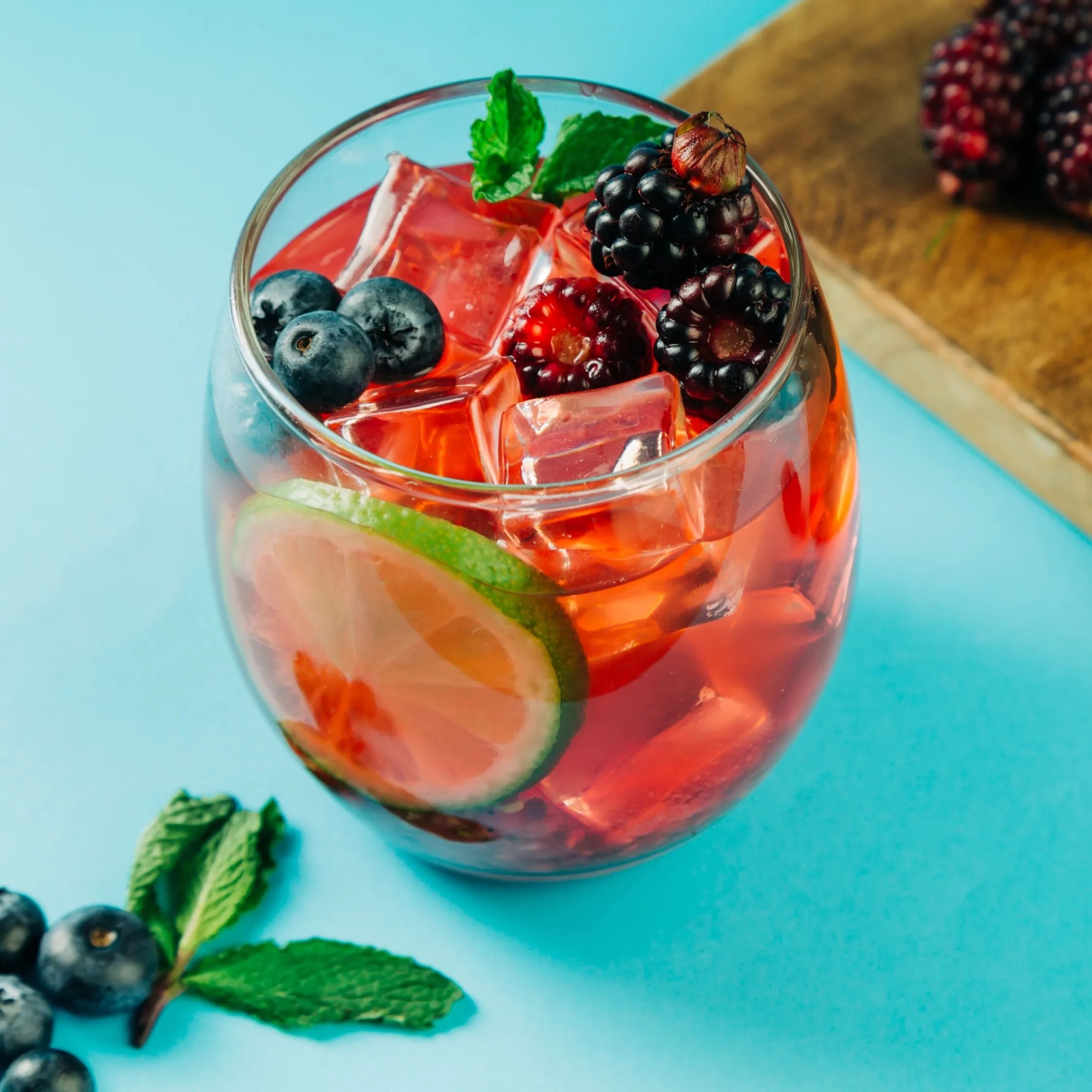 Close-up of a zero-proof berry basil bash with berries and ice.