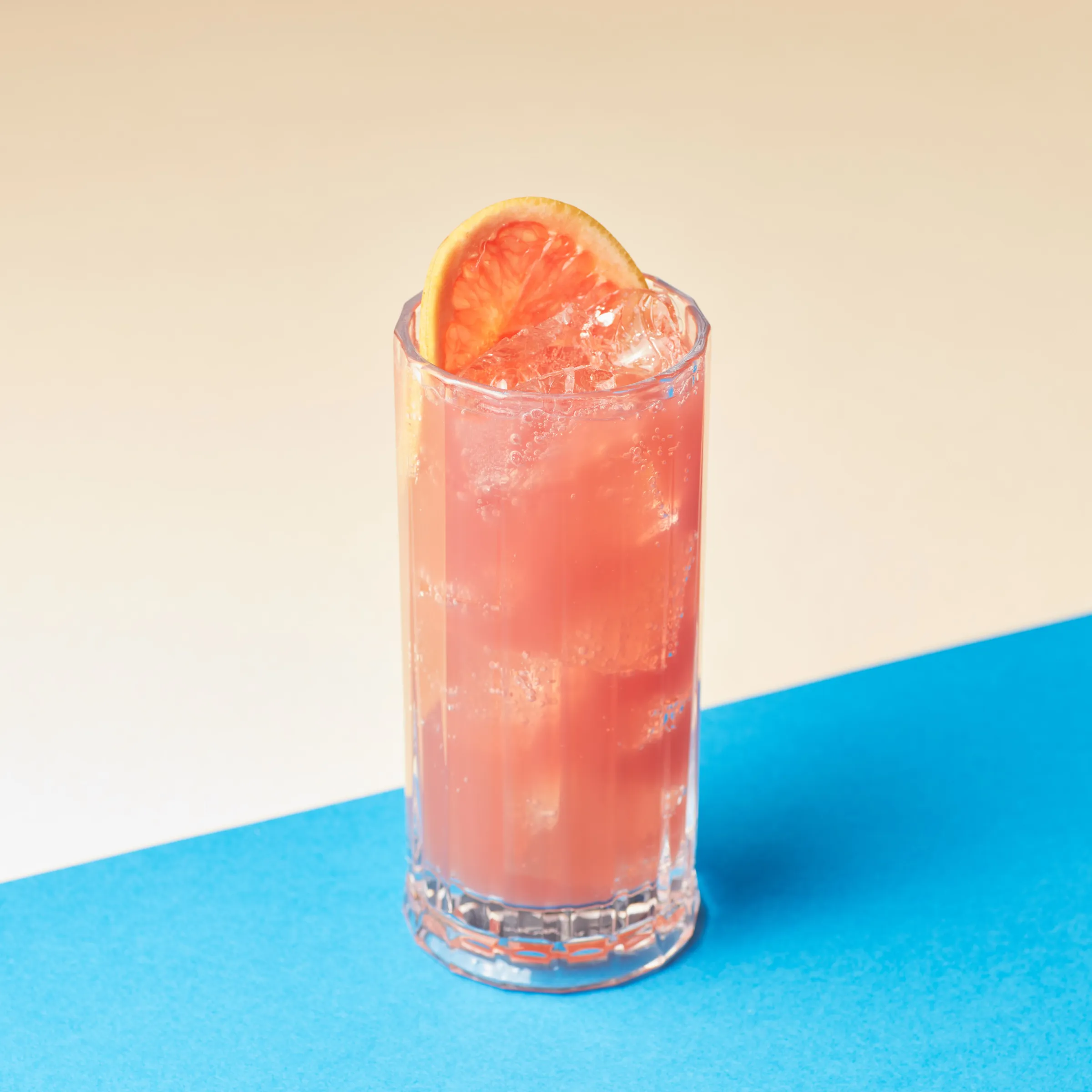 Close-up of a zero-proof paloma with a grapefruit slice and ice.